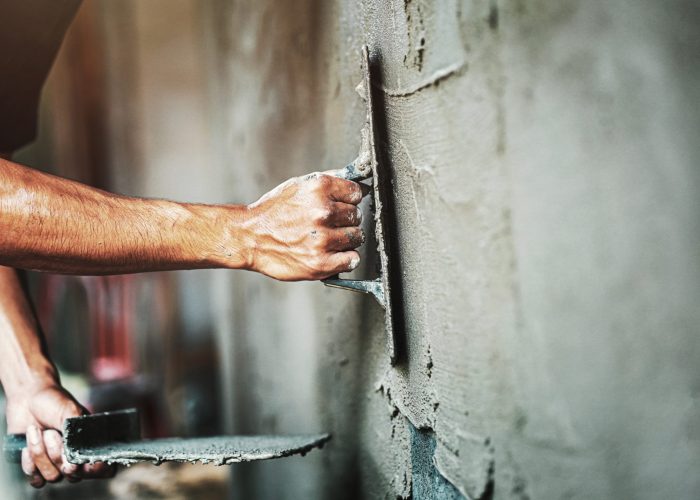 Closeup,Hand,Of,Worker,Plastering,Cement,At,Wall,For,Building